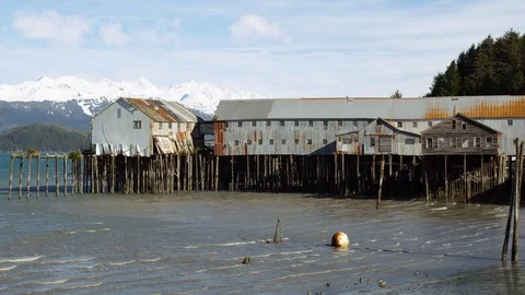 Slow motion of small ocean waves rippling towards seashore close to wooden pier Stock Footage 129111581