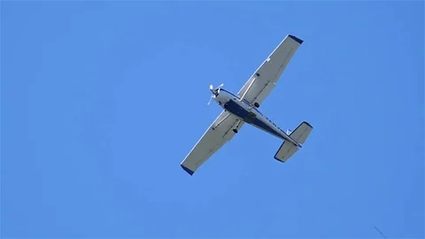 Slow motion of small plane flying overhead in blue sky Video stock 77414281