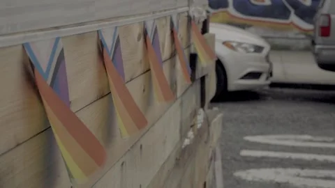 Slow Motion small Pride flags blowing in wind wooden deck Brooklyn NYC 4k Stock Footage 255754448