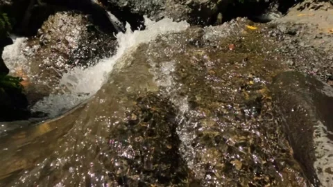 Slow motion of a small river in the rocky mountains flowing gently Stock-Footage 319876376