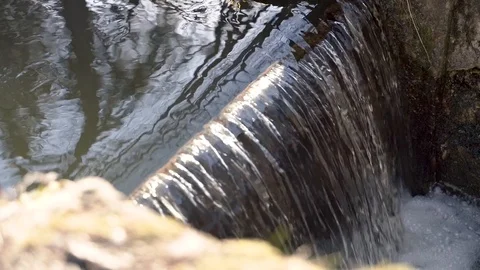 Slow motion of a small a small water bank dam with falling water. Stock Footage 103576628