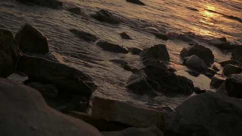 Slow motion small waves among the stones at sunset Stock-Footage 81175527