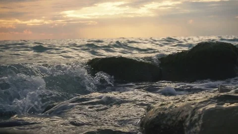 Slow motion small waves are actively rolling on the rocks Stock Footage 81401676