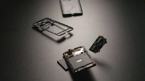 SLOW MOTION: Smartphone falls on a floor, breaks and a parts fly away Video stock 72374618