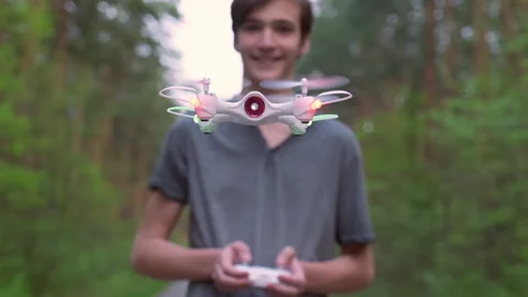 Slow motion. Smiling boy plays with a drone in nature.  Teenager launches a d Stock Footage 131823587