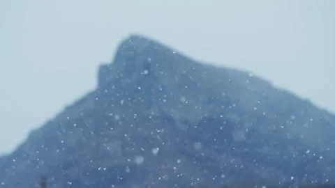 Slow motion snow falls on the background of the mountains and the gray sky. Wint Vídeo Stock 172144004