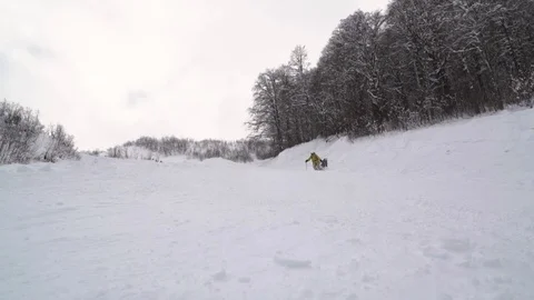 Slow motion of snowboarder dressed up in bright clothes makes snow waves and Video stock 101788193