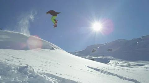 SLOW MOTION: Snowboarder jumping into the powder snow Stock Footage