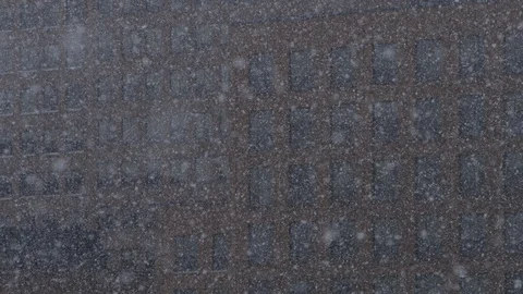 Slow motion snowflakes falling in front of an office building Stock Footage 128075012