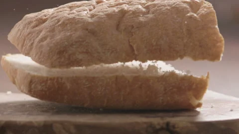 Slow motion soft ciabatta bread fall on olive board Stock Footage 164591120