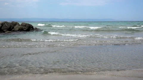 Slow motion of the soft waves of the sea flow into the stone reef in the water Stock Footage 92381537