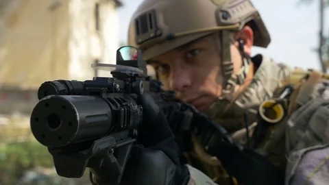 Slow motion of soldier with gun and headset aiming target in tactical operati Stock Footage