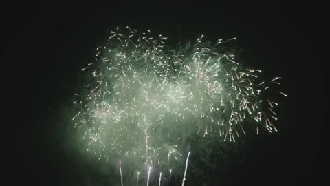 Slow-motion of the sparkle of a fireworks explosion on the dark sky background. Stock Footage 144111637