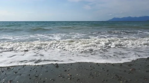 Slow motion, sparkling sea, waves surging on the beach, reflecting the rays of Video stock 130903455