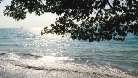 Slow motion, sparkling sea, waves surging on the beach, reflecting the rays of Video stock 130903491