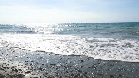 Slow motion, sparkling sea, waves surging on the beach, reflecting the rays of Stock Footage 130903643