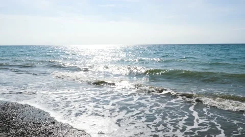 Slow motion, sparkling sea, waves surging on the beach, reflecting the rays of Video stock 130904345