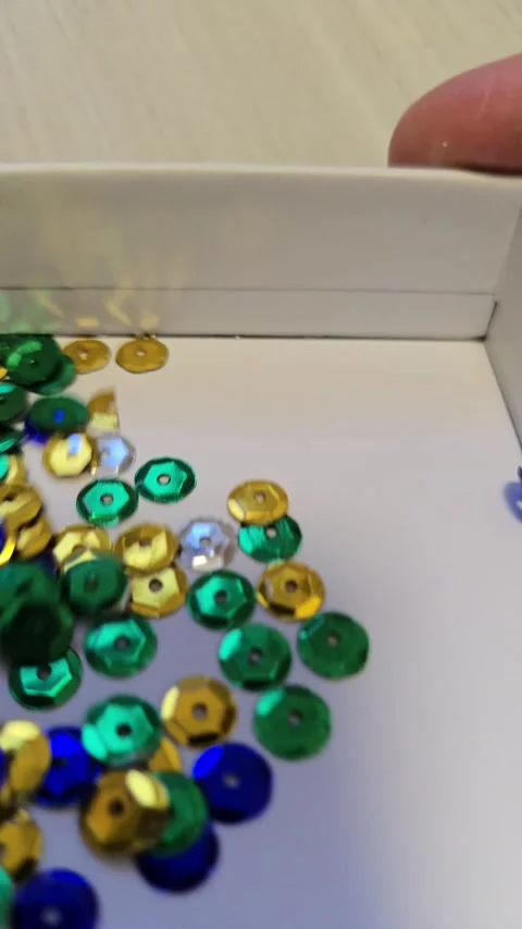 Slow Motion of Sparkling Sequins Falling into Box for Light Reflection Physics Stock Footage 330955870