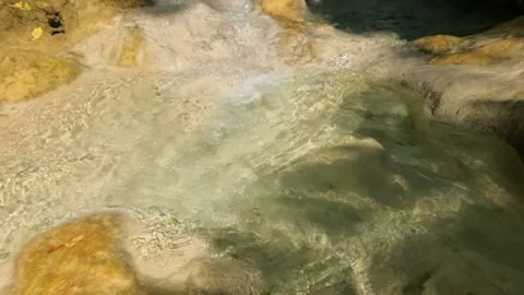 Slow motion of the sparkling sunlight on the bottom of a clear and shallow river Stock Footage 321321685