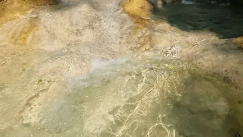 Slow motion of the sparkling sunlight on the bottom of a clear and shallow river Stock Footage 321321687