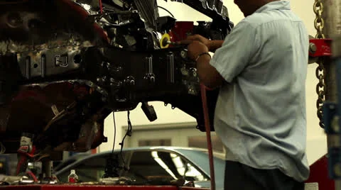 Slow motion sparks shooting as a tech grinds at vehicle frame rail 스톡 동영상 25879093