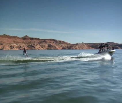 Slow-motion speedboat pulls wake boarder Lake Powell Utah Stock Footage 21660273