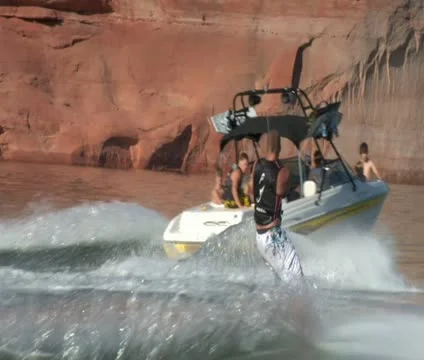 Slow-motion speedboat pulls wake boarder Lake Powell Utah zoom shot Stock Footage 21660359