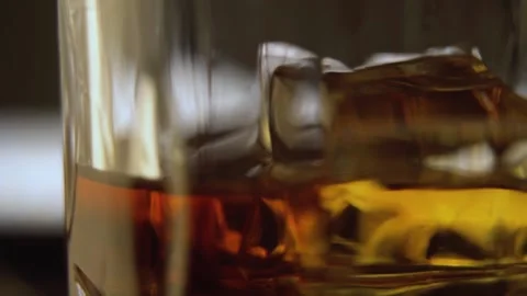 Slow Motion Spinning Shot of Whisky on the Rocks Stock Footage