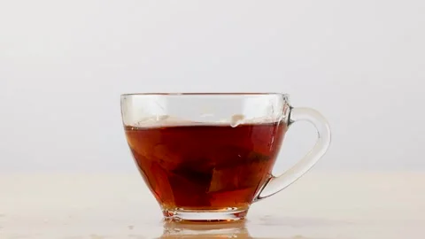 Slow Motion Splash of Hot Tea in Clear Glass Cup Stock Footage 341644447