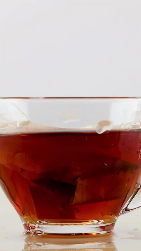Slow Motion Splash of Hot Tea in a Clear Glass Cup Stock Footage 342582394