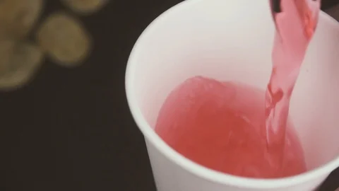 Slow motion splash of red drink in a glass on a table Stock Footage 87795997