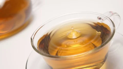 SLOW MOTION: Splash - Teardrop falls in a teacup on a white table Stock Footage 70572594