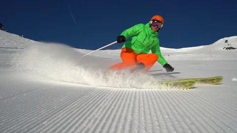 Slow motion splashing snow skier carving on ski piste Stock Footage 103997885