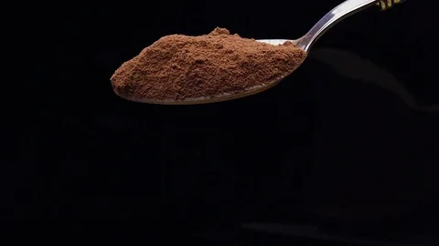 Slow motion spoon cocoa powder falling against balck background Stock Footage 124087211