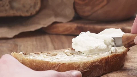 Slow motion of spreading ricotta cheese on fresh rustic bread 스톡 동영상 74764431