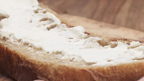 Slow motion of spreading ricotta cheese on fresh rustic bread Stock Footage 78128890
