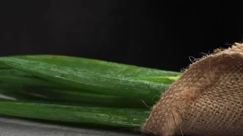 Slow motion of spring onion with gunny sack fall on the table Stock Footage 277682345