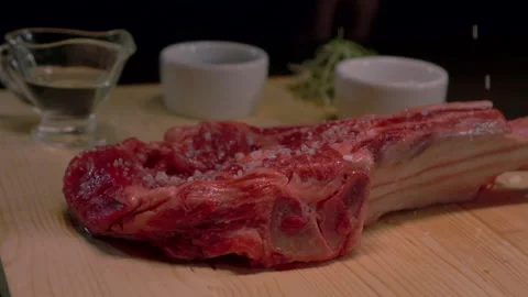 Slow motion sprinkling salt to raw beef. Stock Footage 221496059