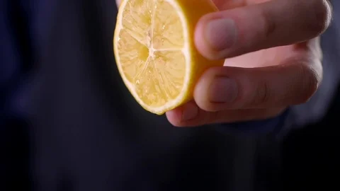 Slow Motion squeeze juice from lemon, hand squeezes half yellow lemon Video stock 122169213