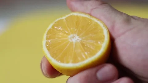 Slow Motion squeeze juice from lemon, hand squeezes half yellow lemon. Stock Footage 131844295