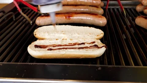 Slow Motion Squeezing BBQ Sauce onto Grilled Hot Dog Bun on Outdoor Barbecue Gri Stock Footage 331954244