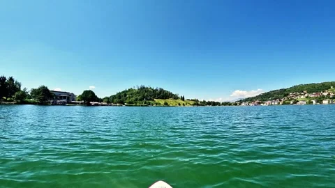 Slow-motion of stand up paddleboarding POV in a lake surrounded by hills  Stock Footage 339542394