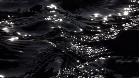 Slow motion of standing waves on black water surface in sun shine reflection. Stock Footage 99143439