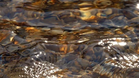 Slow motion of standing waves on shallow pure water with brown pebble bottom Video stock 98096052