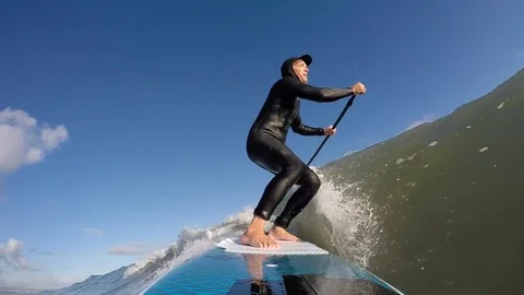 Slow motion standup paddle board (SUP) surfing a wave in winter, New Zealand Stock Footage