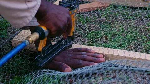 Slow Motion Stapling Wire Mesh to Wooden Frame Stock Footage 320840998