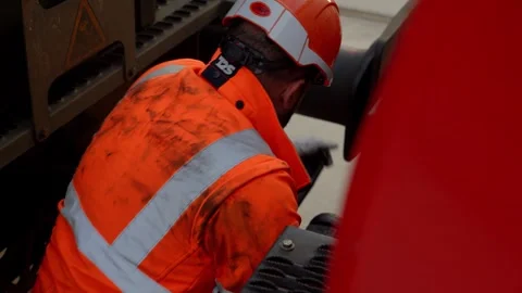 Slow motion Static Shot of Rail Worker in Orange Hi-Vis Inspects Train Cargo Stock Footage 338371669