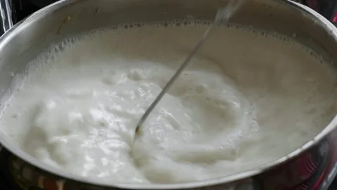 Slow Motion Stirring of Milk in Pot with Bubbles Stock Footage 330390082
