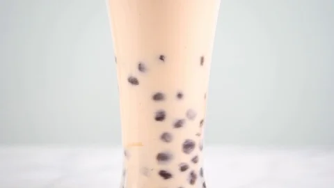 Slow motion stirring tapioca pearl bubble milk tea in drinking glass. Stock Footage 112696671
