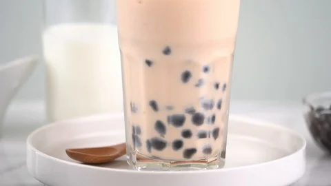 Slow motion stirring tapioca pearl bubble milk tea in drinking glass. Stock Footage 112696870